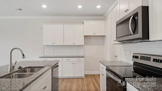 a kitchen with a sink stove and cabinets