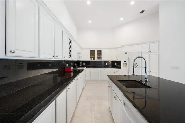 a kitchen with granite countertop a sink and cabinets