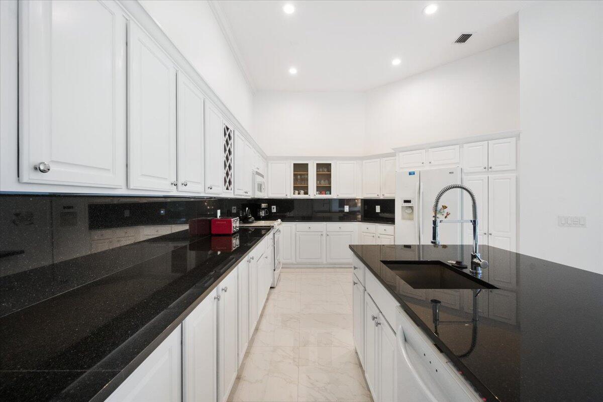 2514 Players Court Wellington, FL 33414 - Photo 11 of 30 a kitchen with granite countertop a sink and cabinets