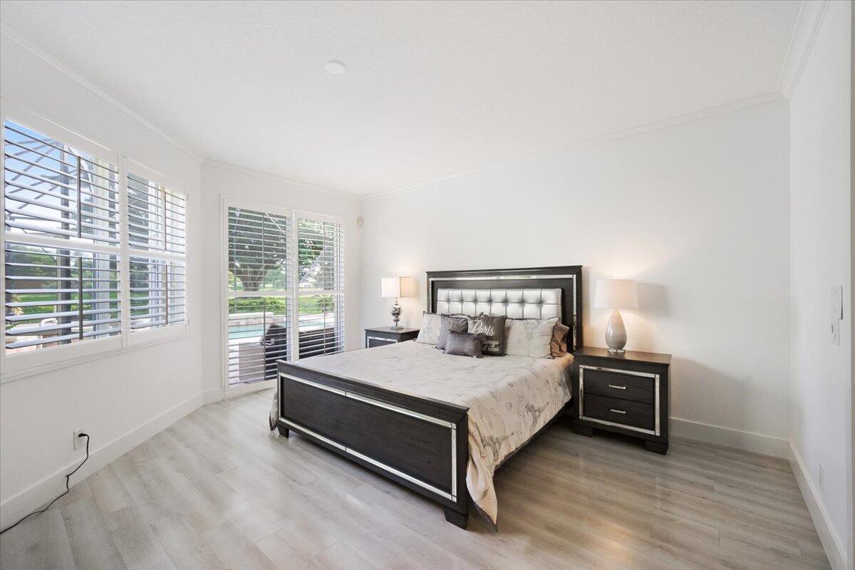2514 Players Court Wellington, FL 33414 - Photo 13 of 30 a bedroom with a bed lamp and a window