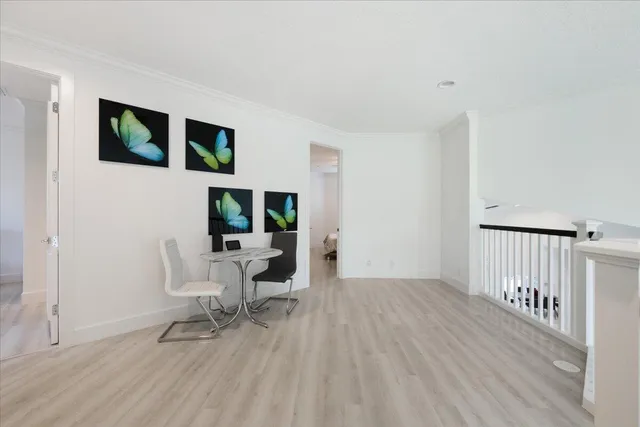 a bedroom with a bed a mirror on dresser and a flat screen tv