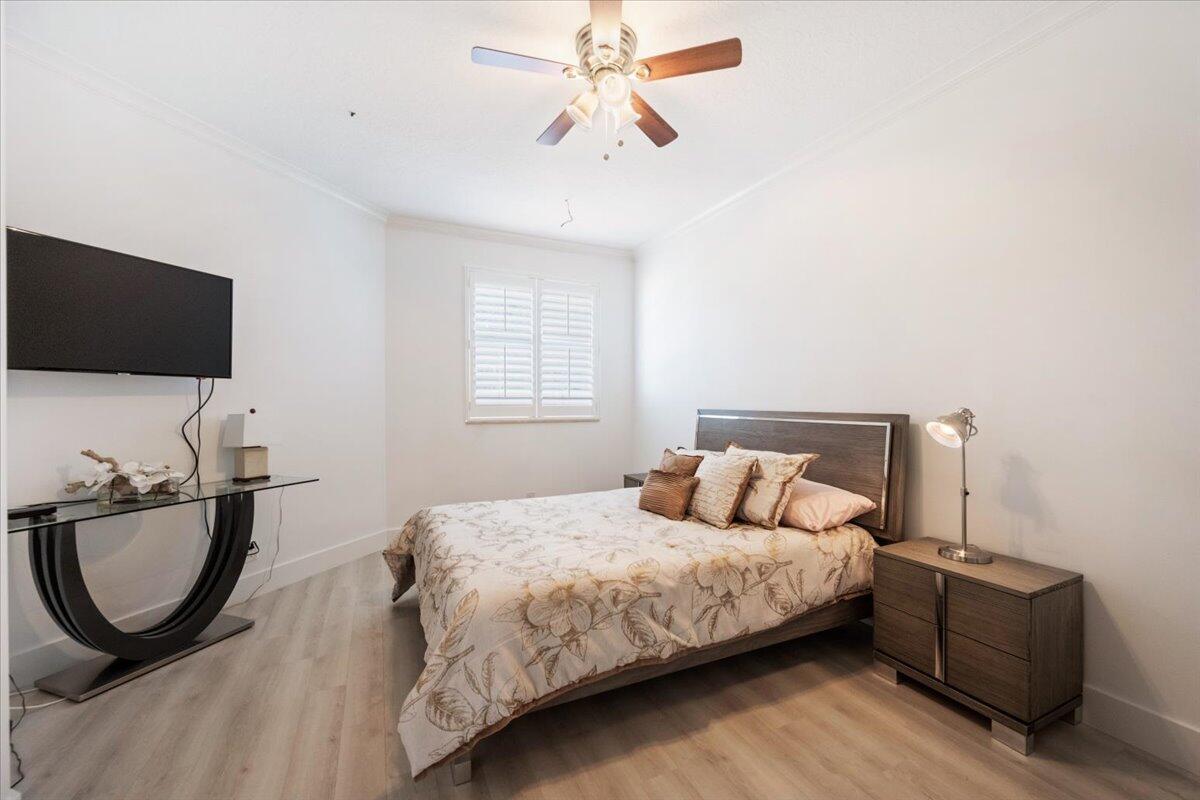 2514 Players Court Wellington, FL 33414 - Photo 21 of 30 a bedroom with a bed a mirror on dresser and a flat screen tv