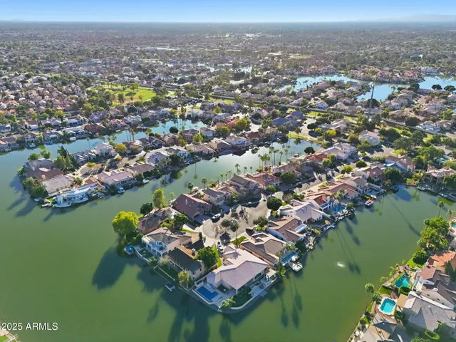an aerial view of a city with lots of residential buildings ocean and mountain view in back