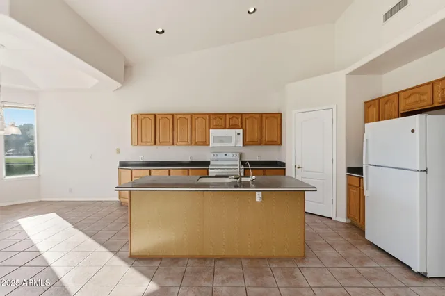 a view of a kitchen with stainless steel appliances granite countertop a refrigerator and a stove