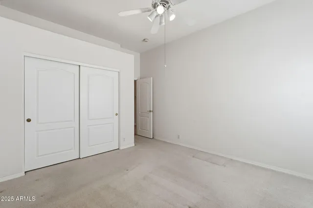 an empty room with a ceiling fan and a window