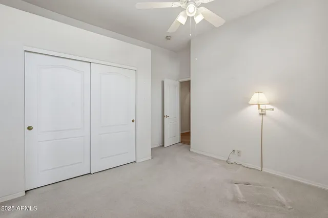an empty room with a chandelier fan