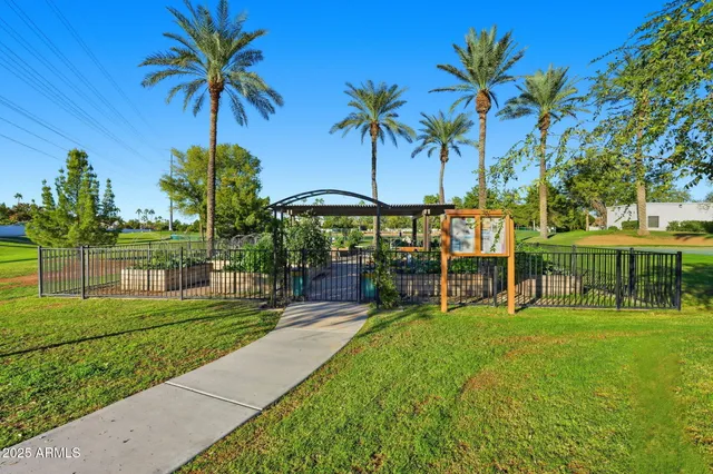 a view of a yard with a table and chairs under an umbrella