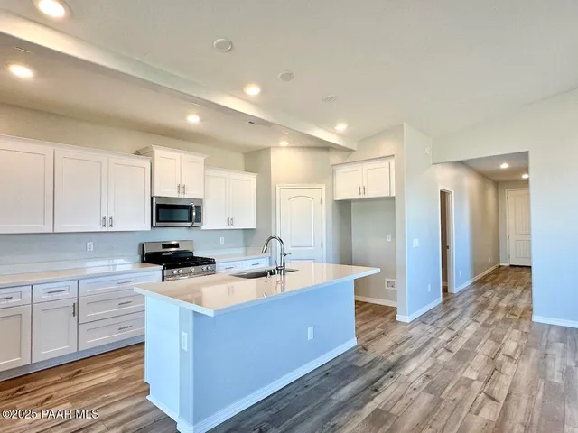 a kitchen with stainless steel appliances granite countertop a sink a stove and a refrigerator