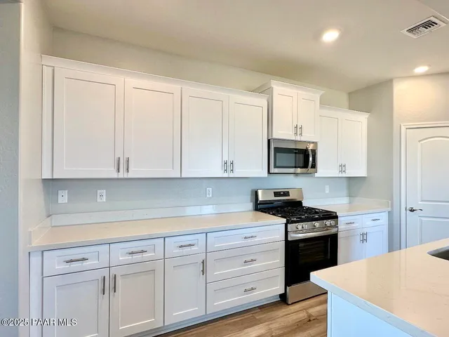 a kitchen with stainless steel appliances granite countertop white cabinets a sink and dishwasher
