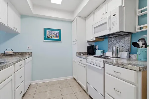 a kitchen with white cabinets and sink