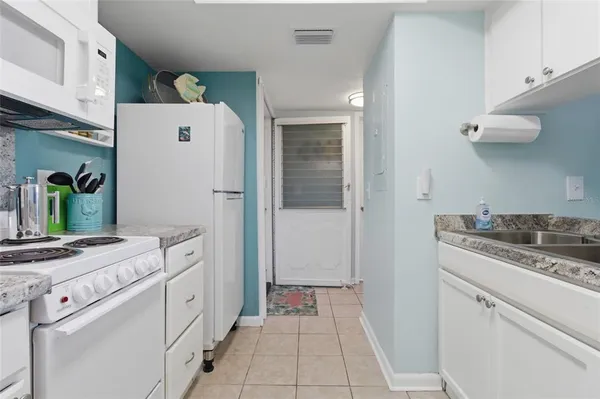 a kitchen with white cabinets and appliances
