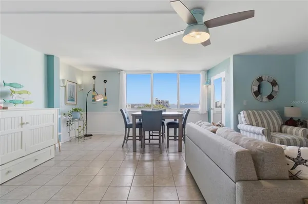 a dining room with furniture and a chandelier fan