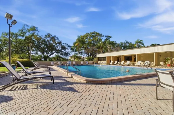 a front view of a house with swimming pool and sitting area