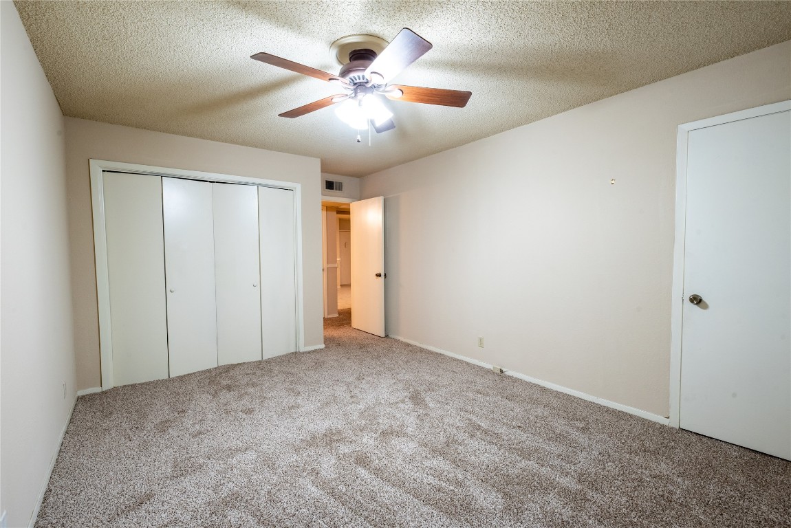 910 Duncan Lane, Unit 56 Austin, TX 78705 - Photo 13 of 13 an empty room with chandelier fan and windows