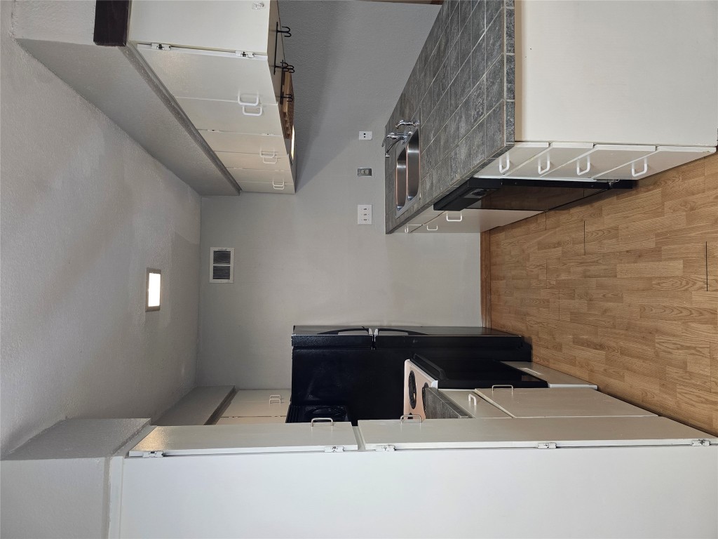 910 Duncan Lane, Unit 56 Austin, TX 78705 - Photo 5 of 13 a kitchen with granite countertop a stove and a refrigerator