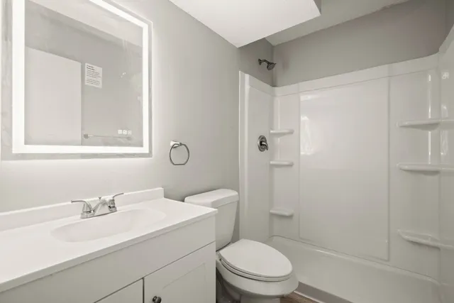 a bathroom with a sink toilet vanity and shower