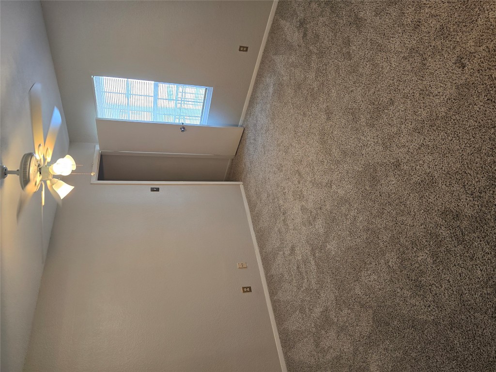 910 Duncan Lane, Unit 56 Austin, TX 78705 - Photo 9 of 13 an empty room with windows and chandelier fan