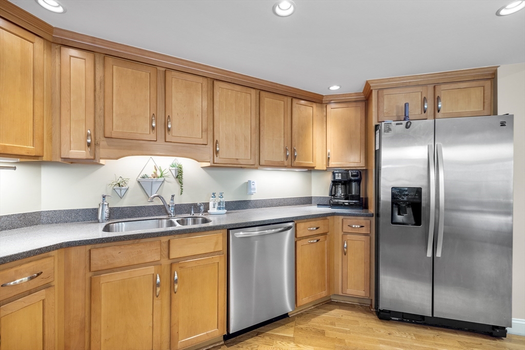 490 Main Street, Unit 215 Northborough, MA 01532 - Photo 12 of 37 a kitchen with stainless steel appliances granite countertop a refrigerator sink and cabinets