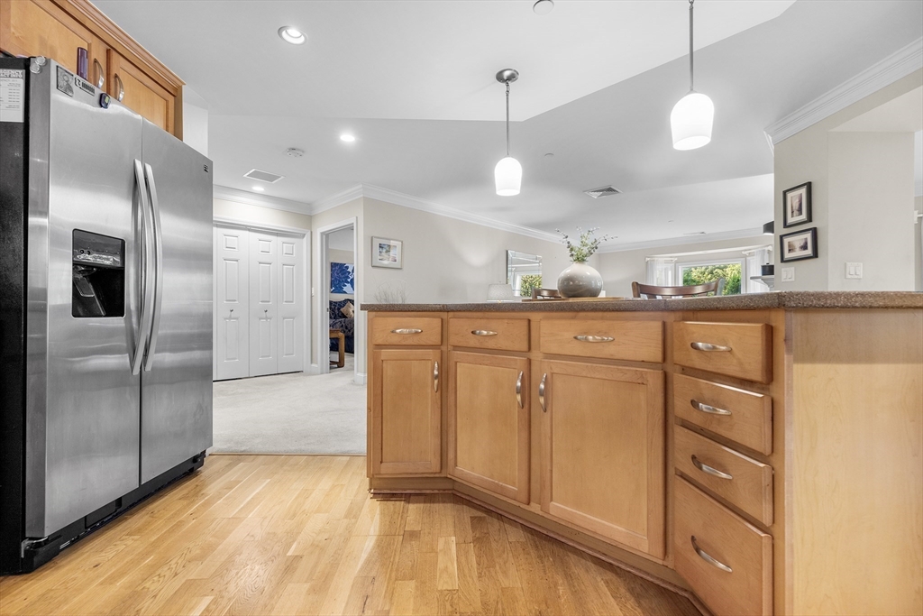 490 Main Street, Unit 215 Northborough, MA 01532 - Photo 13 of 37 a kitchen with granite countertop a refrigerator and a sink