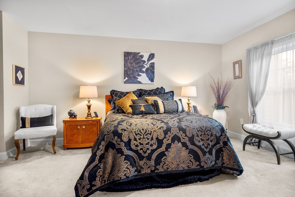 490 Main Street, Unit 215 Northborough, MA 01532 - Photo 20 of 37 a bedroom with a bed and chair