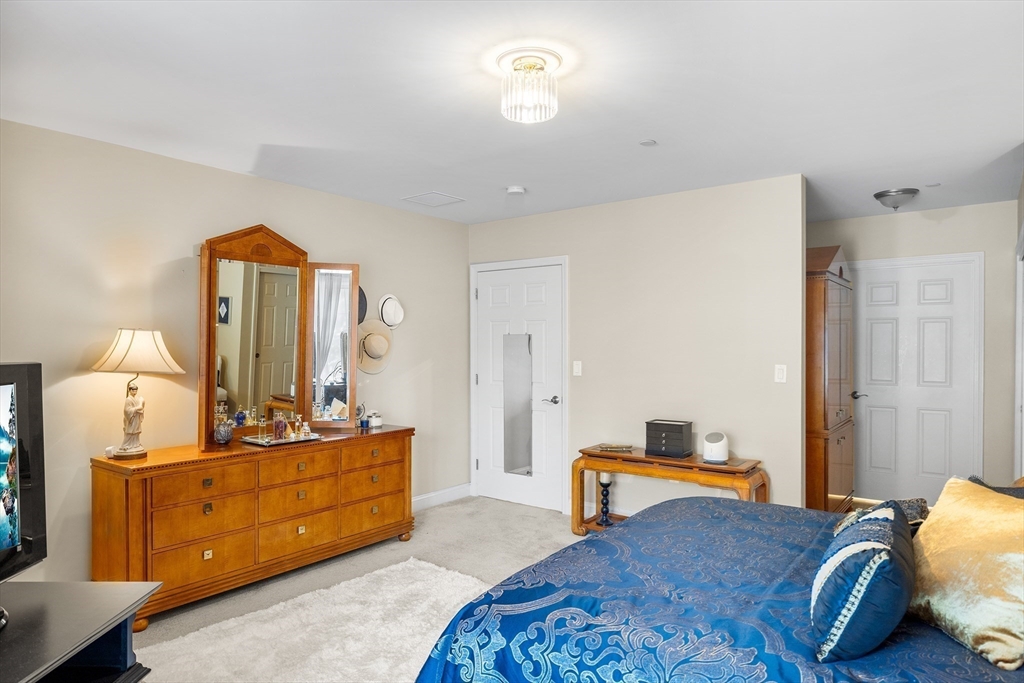 490 Main Street, Unit 215 Northborough, MA 01532 - Photo 21 of 37 a bedroom with a bed and wooden floor