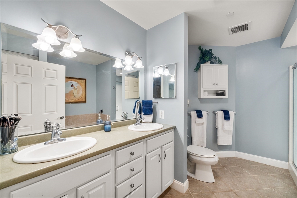 490 Main Street, Unit 215 Northborough, MA 01532 - Photo 23 of 37 a bathroom with a toilet sink and mirror