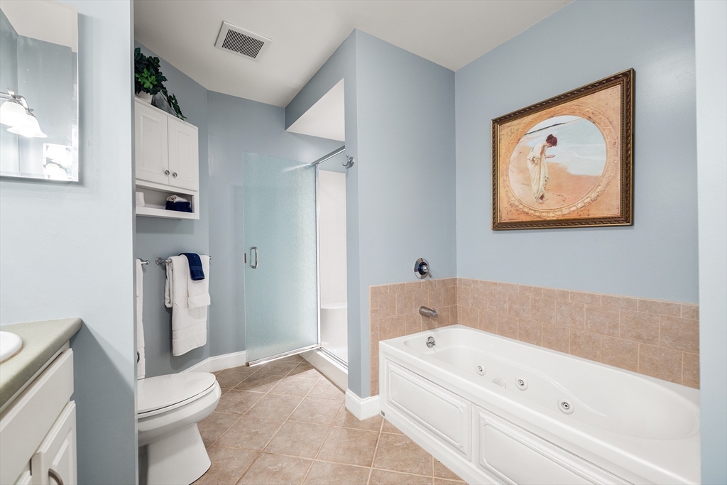 490 Main Street, Unit 215 Northborough, MA 01532 - Photo 24 of 37 a bathroom with a bathtub and a toilet