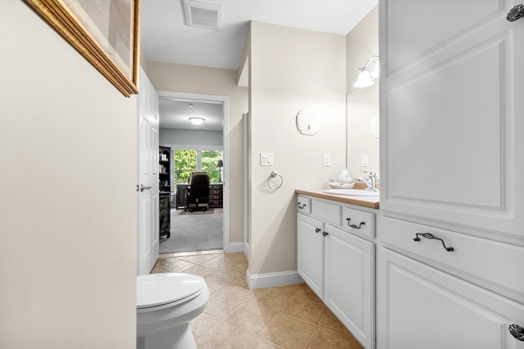 490 Main Street, Unit 215 Northborough, MA 01532 - Photo 28 of 37 a bathroom with a granite countertop sink toilet and shower