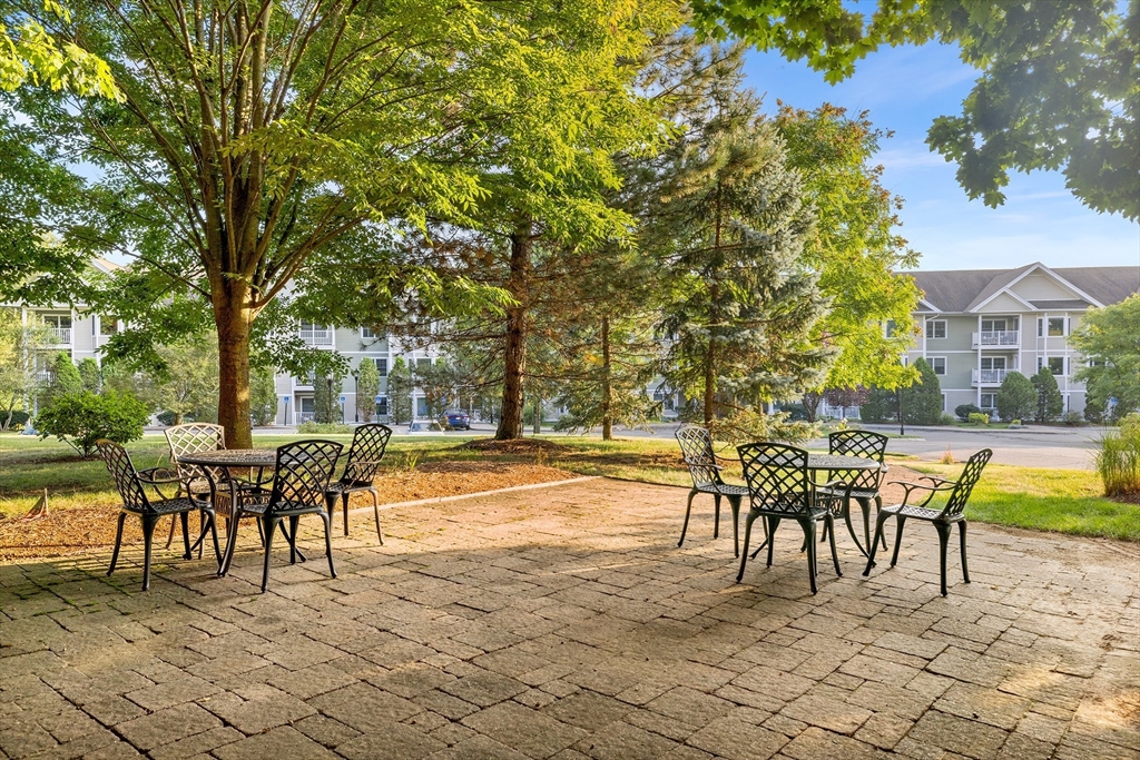 490 Main Street, Unit 215 Northborough, MA 01532 - Photo 5 of 37 a patio with a table and chairs