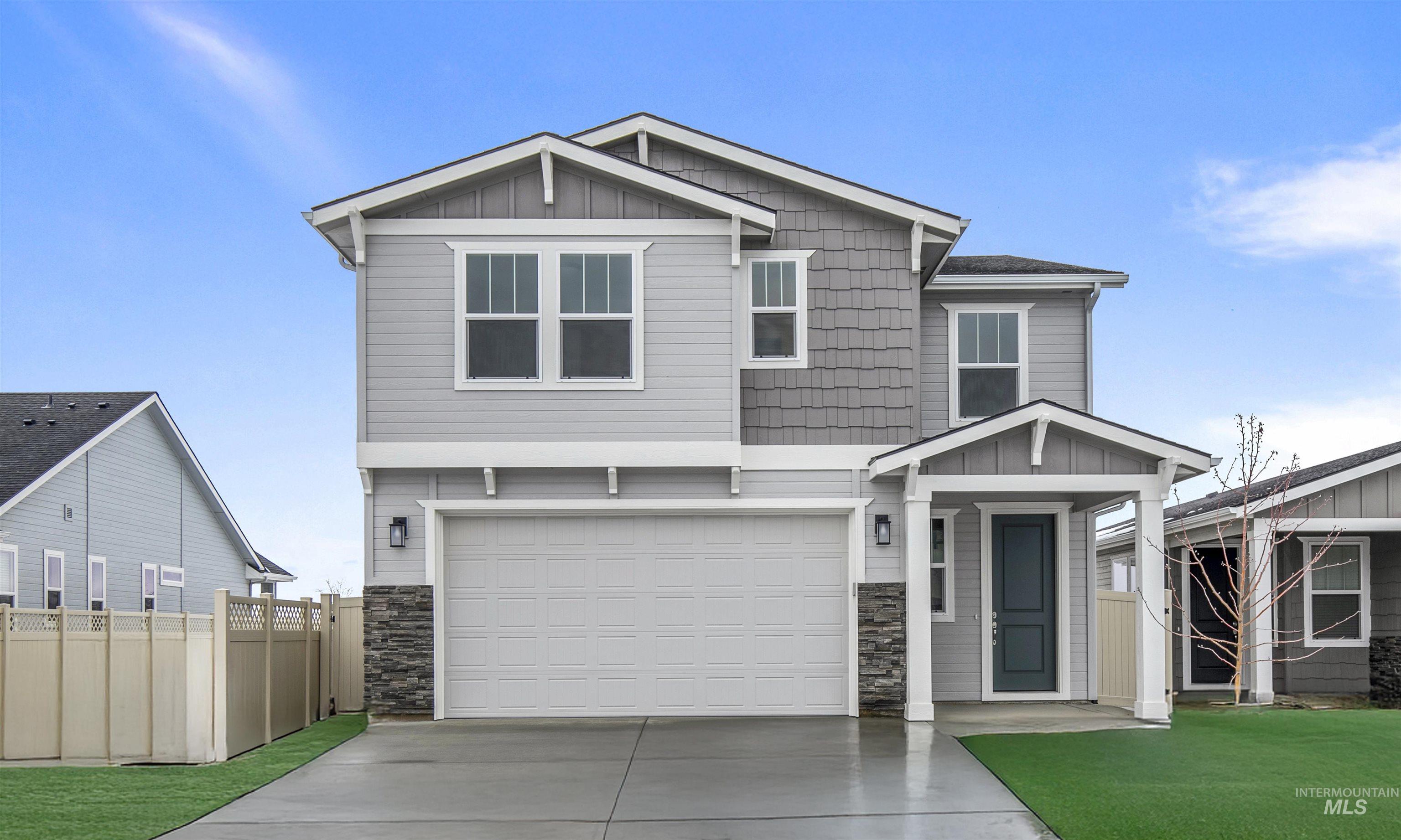 Craftsman-style home with board and batten siding, stone siding, an attached garage, and concrete driveway