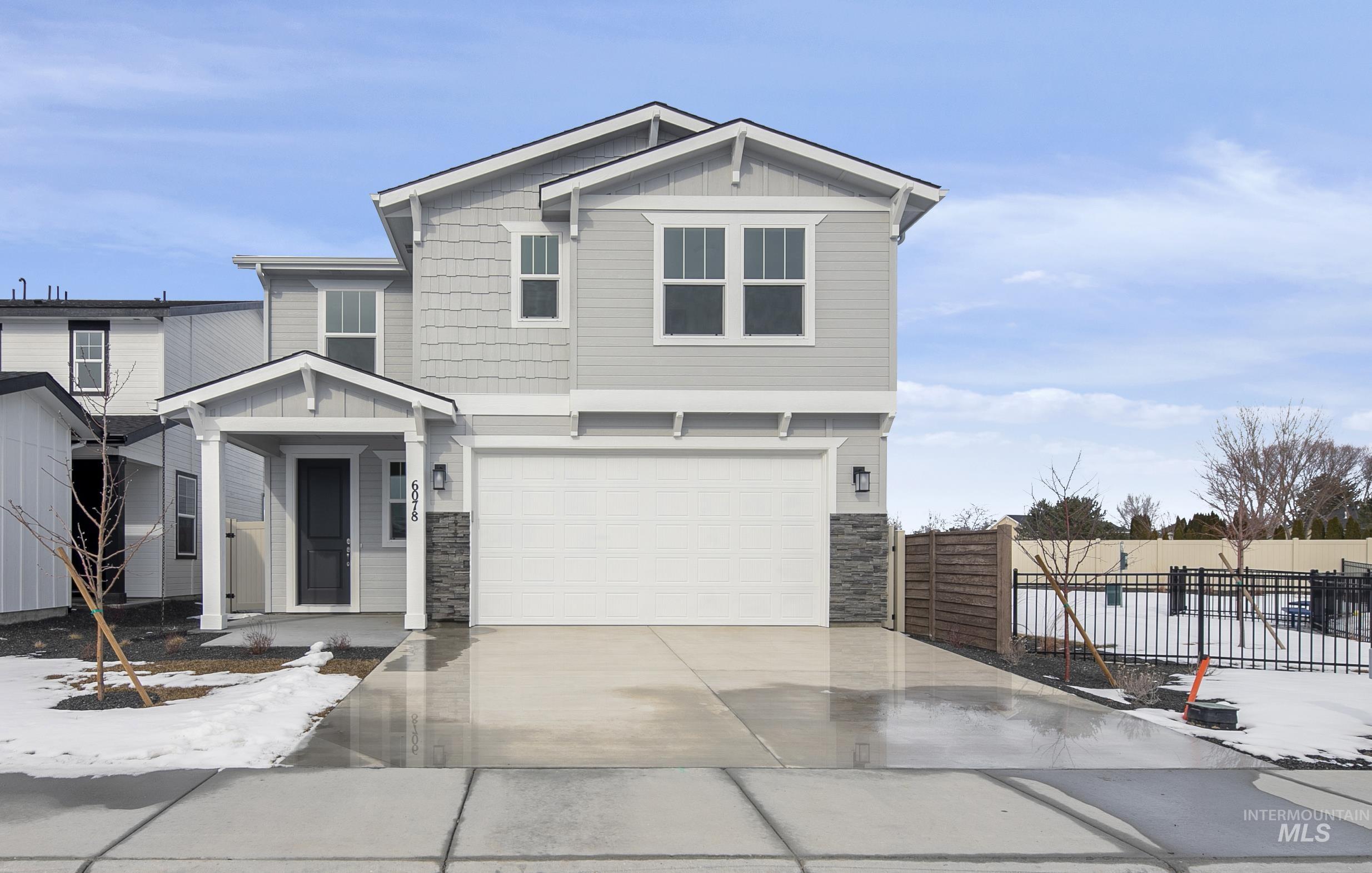 5985 North Backfire Way Meridian, ID 83646 - Photo 15 of 17 View of front of home featuring board and batten siding, stone siding, an attached garage, and concrete driveway
