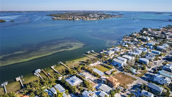 an aerial view of ocean and residential houses with outdoor space