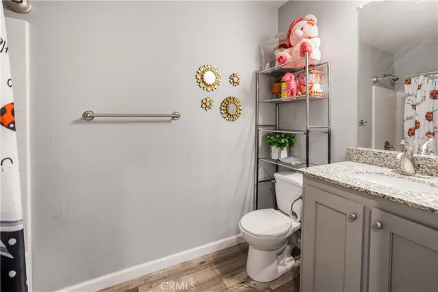 a bathroom with a granite countertop toilet and a sink