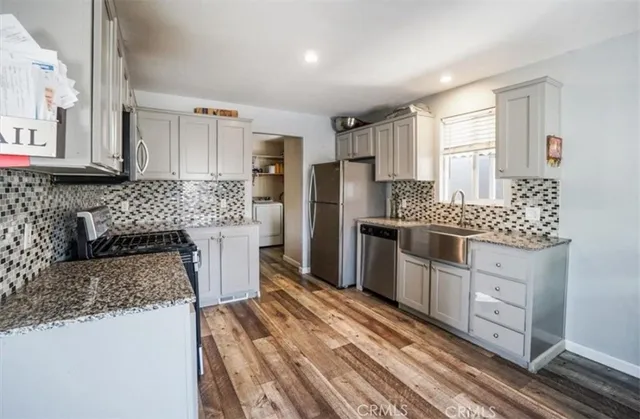 a kitchen with stainless steel appliances granite countertop a stove a sink and a refrigerator