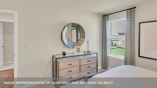 a bedroom with a bed a mirror on dresser and a window