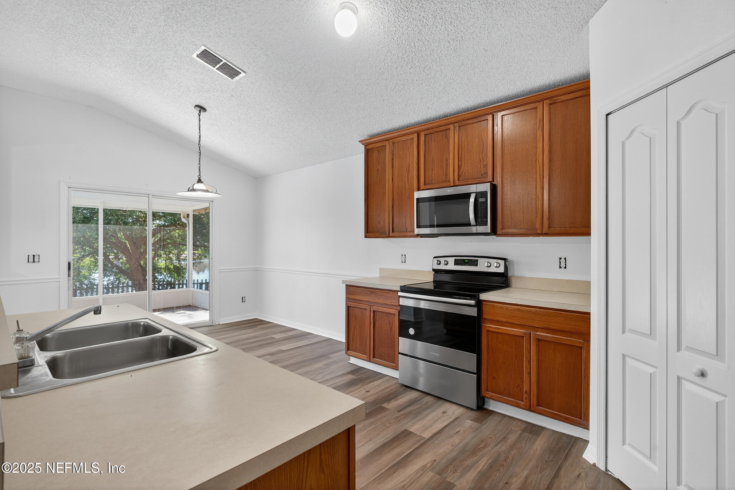10174 Rising Mist Lane Jacksonville, FL 32221 - Photo 13 of 31 a kitchen with stainless steel appliances a stove a sink and a microwave