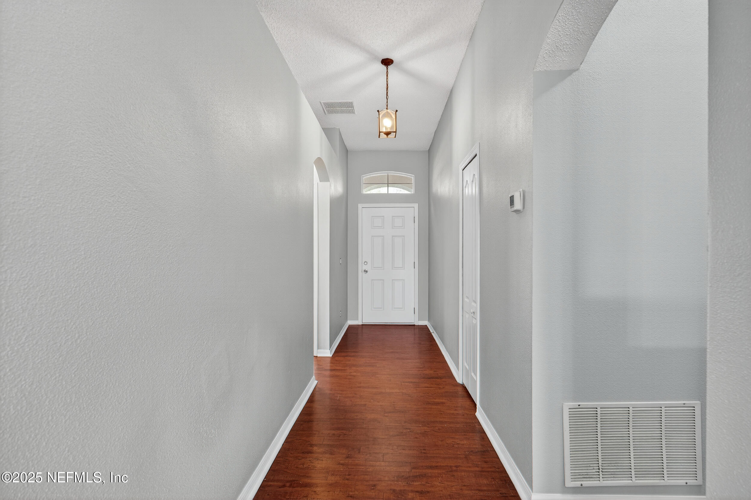 10174 Rising Mist Lane Jacksonville, FL 32221 - Photo 17 of 31 a view of a hallway with wooden floor and a front door