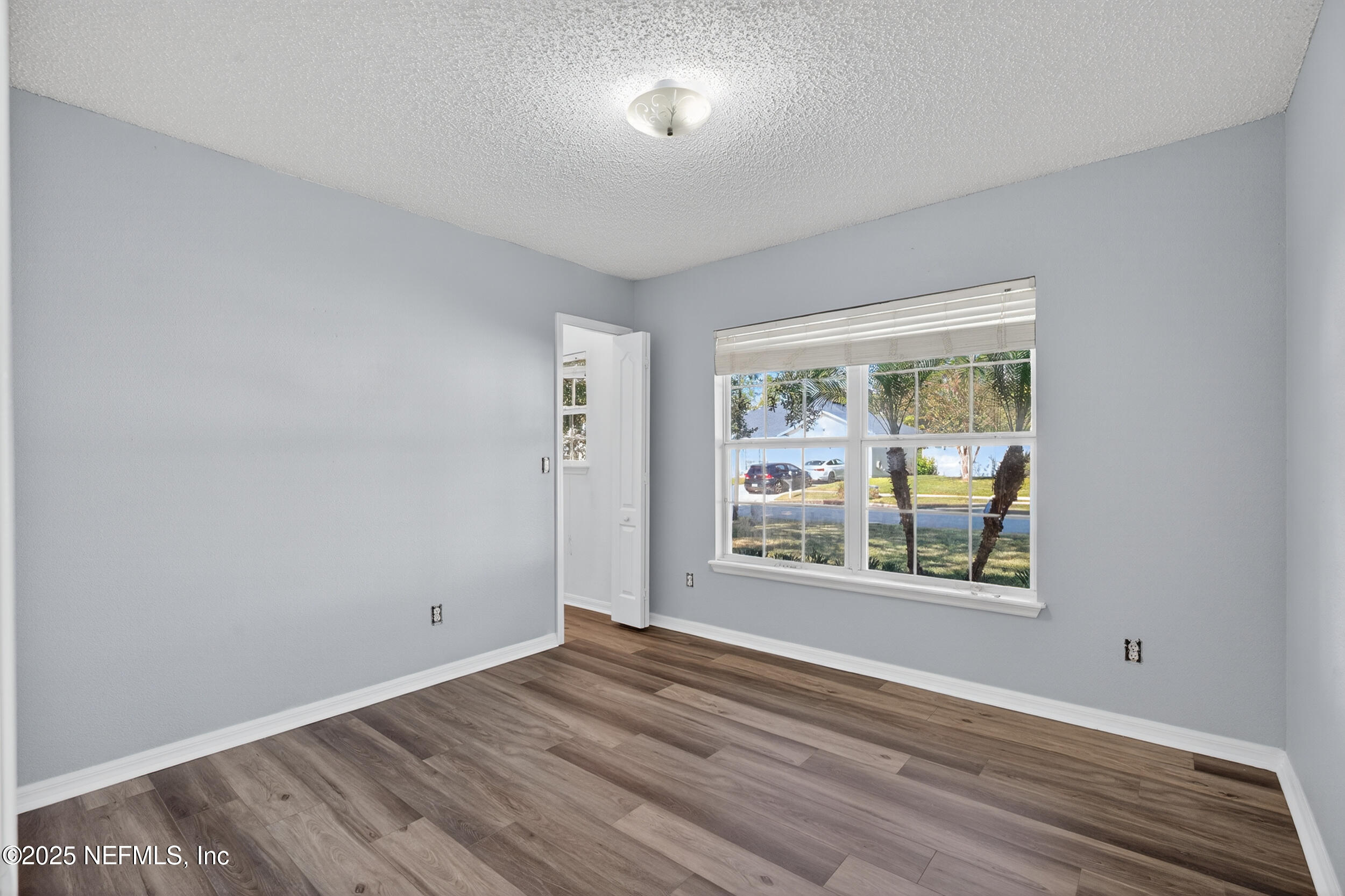 10174 Rising Mist Lane Jacksonville, FL 32221 - Photo 24 of 31 an empty room with wooden floor and windows