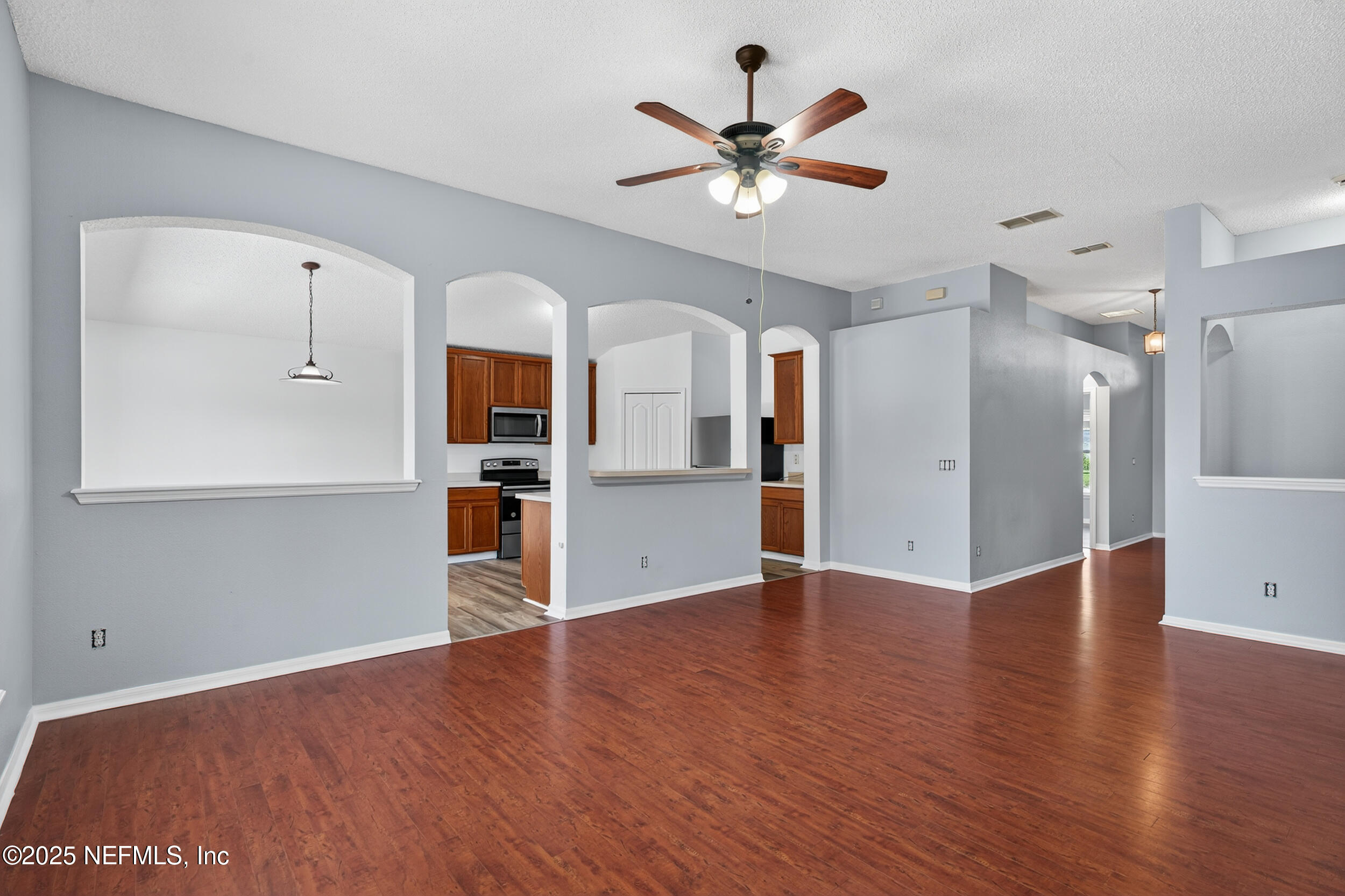 10174 Rising Mist Lane Jacksonville, FL 32221 - Photo 5 of 31 an empty room with wooden floor and windows
