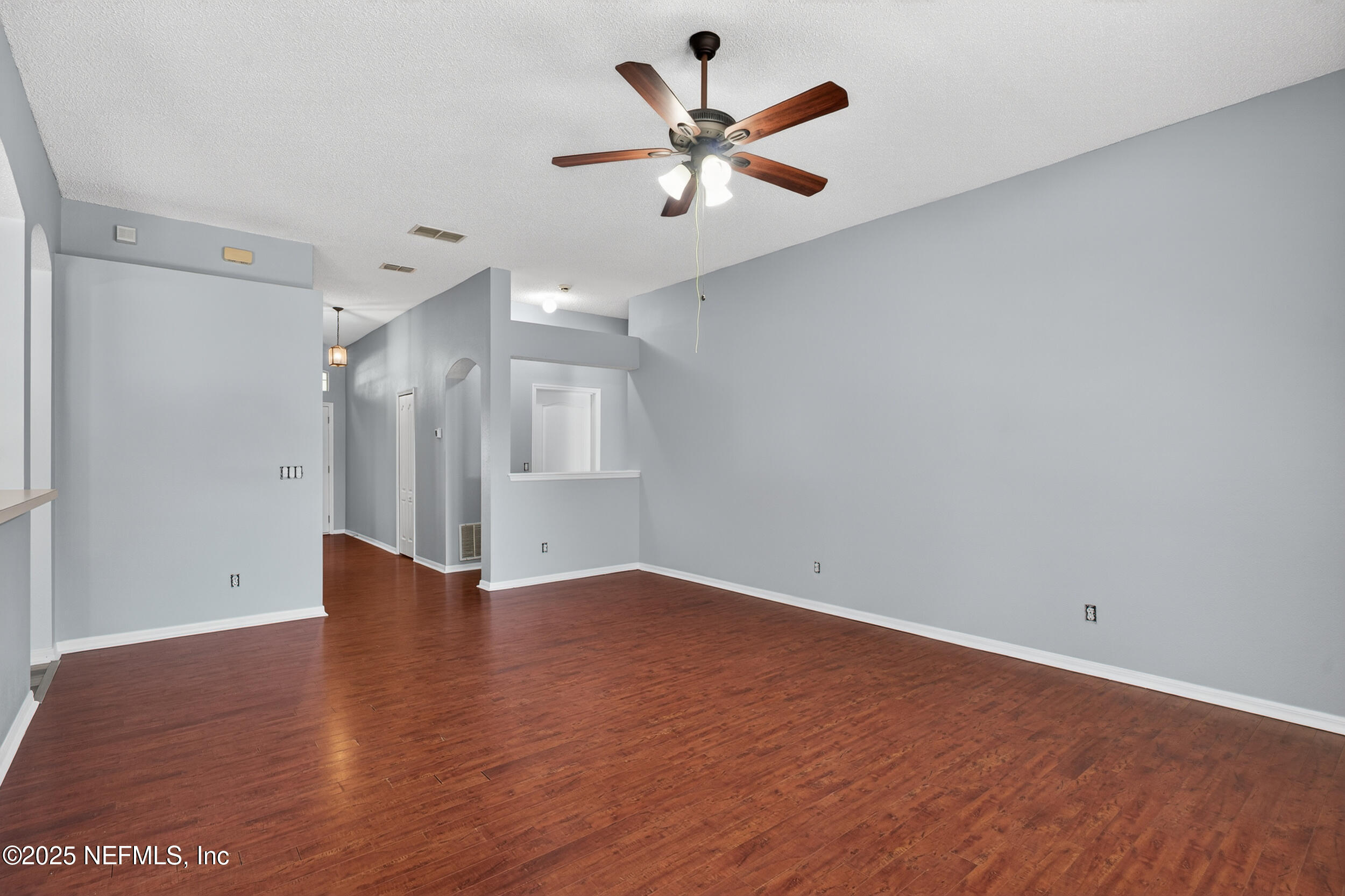 10174 Rising Mist Lane Jacksonville, FL 32221 - Photo 6 of 31 an empty room with wooden floor and windows