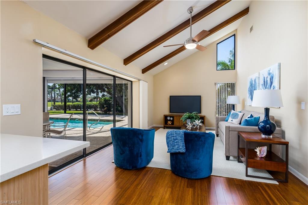 1172 Kings Way Naples, FL 34104 - Photo 3 of 50 a living room with couches chairs and a large window with wooden floor
