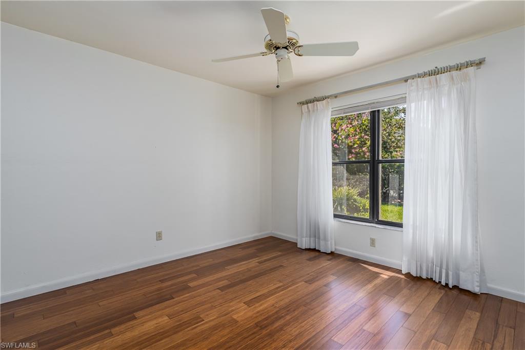 1172 Kings Way Naples, FL 34104 - Photo 33 of 50 an empty room with wooden floor chandelier fan and windows