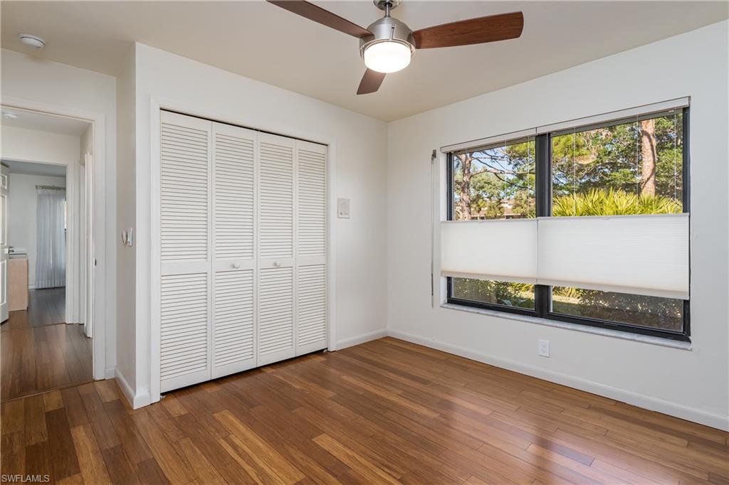 1172 Kings Way Naples, FL 34104 - Photo 36 of 50 an empty room with wooden floor and windows