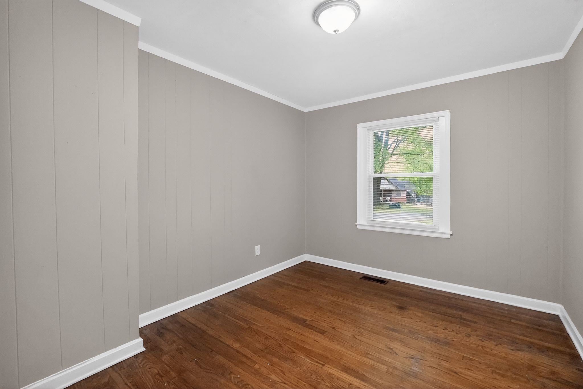 4067 Grantham Road Memphis, TN 38109 - Photo 16 of 34 Spare room with dark wood-style floors and crown molding