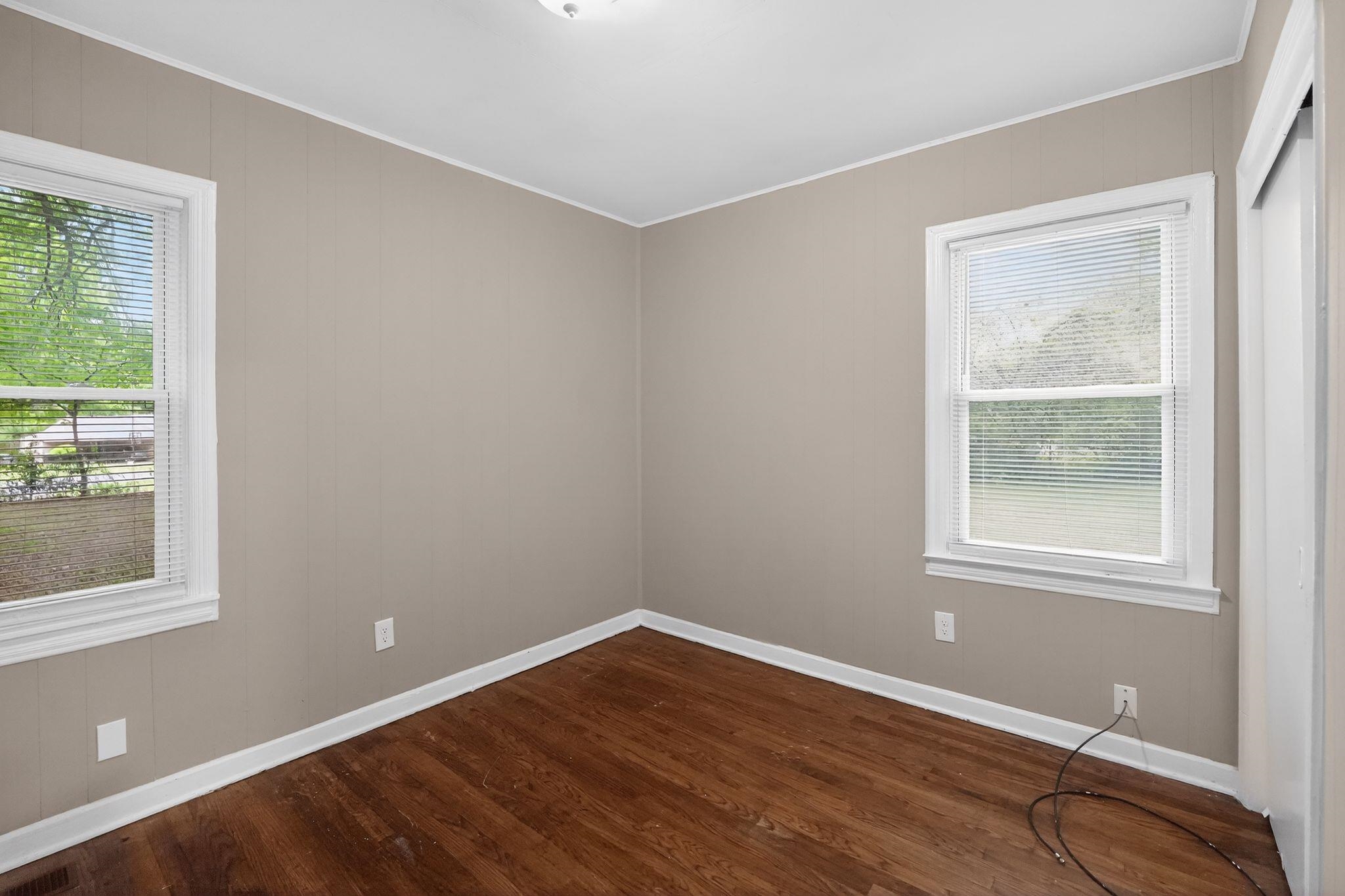 4067 Grantham Road Memphis, TN 38109 - Photo 19 of 34 Spare room with dark wood-type flooring, ornamental molding, and wooden walls