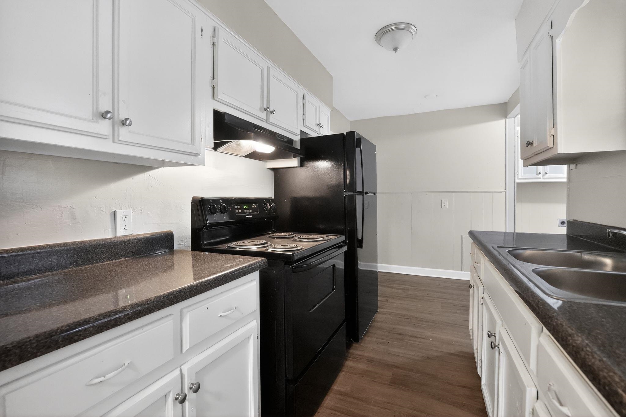 4067 Grantham Road Memphis, TN 38109 - Photo 23 of 34 Kitchen featuring black appliances, dark wood-type flooring, and white cabinets