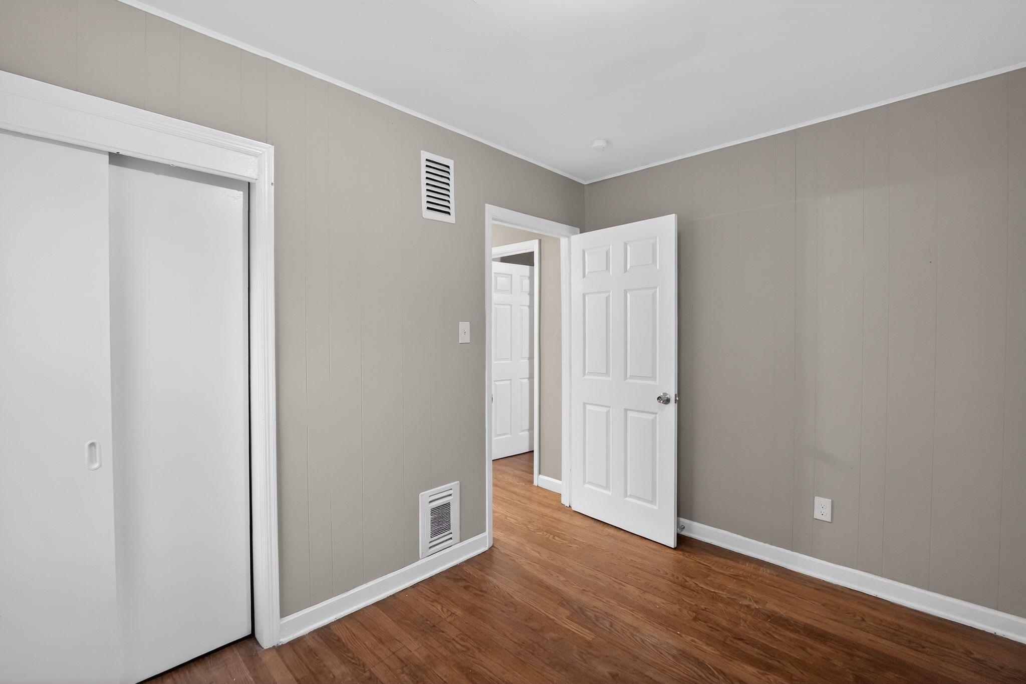 4067 Grantham Road Memphis, TN 38109 - Photo 25 of 34 Unfurnished bedroom with ornamental molding, dark wood-style flooring, and wooden walls