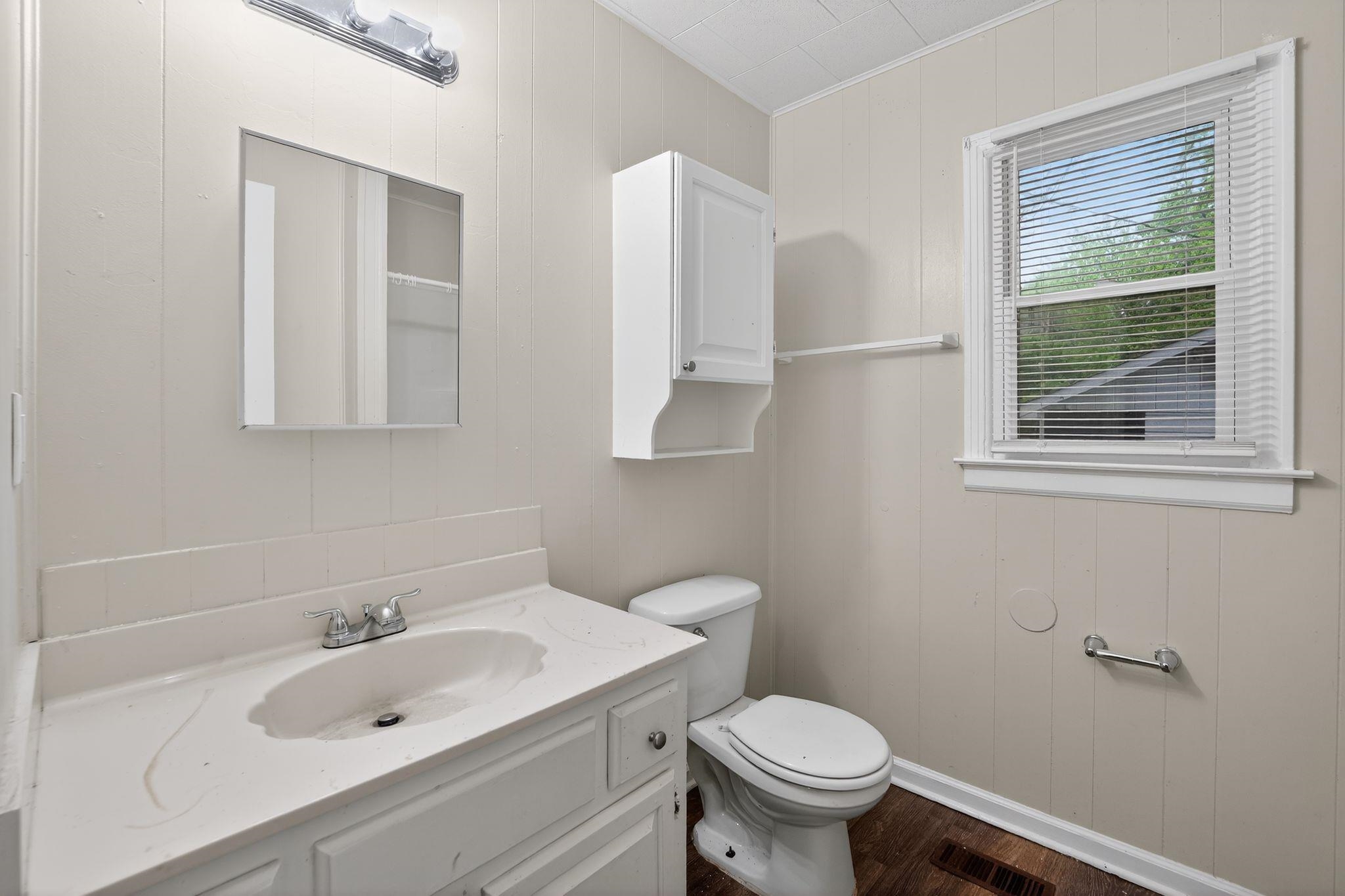 4067 Grantham Road Memphis, TN 38109 - Photo 27 of 34 Bathroom featuring vanity, wood walls, and dark wood-type flooring