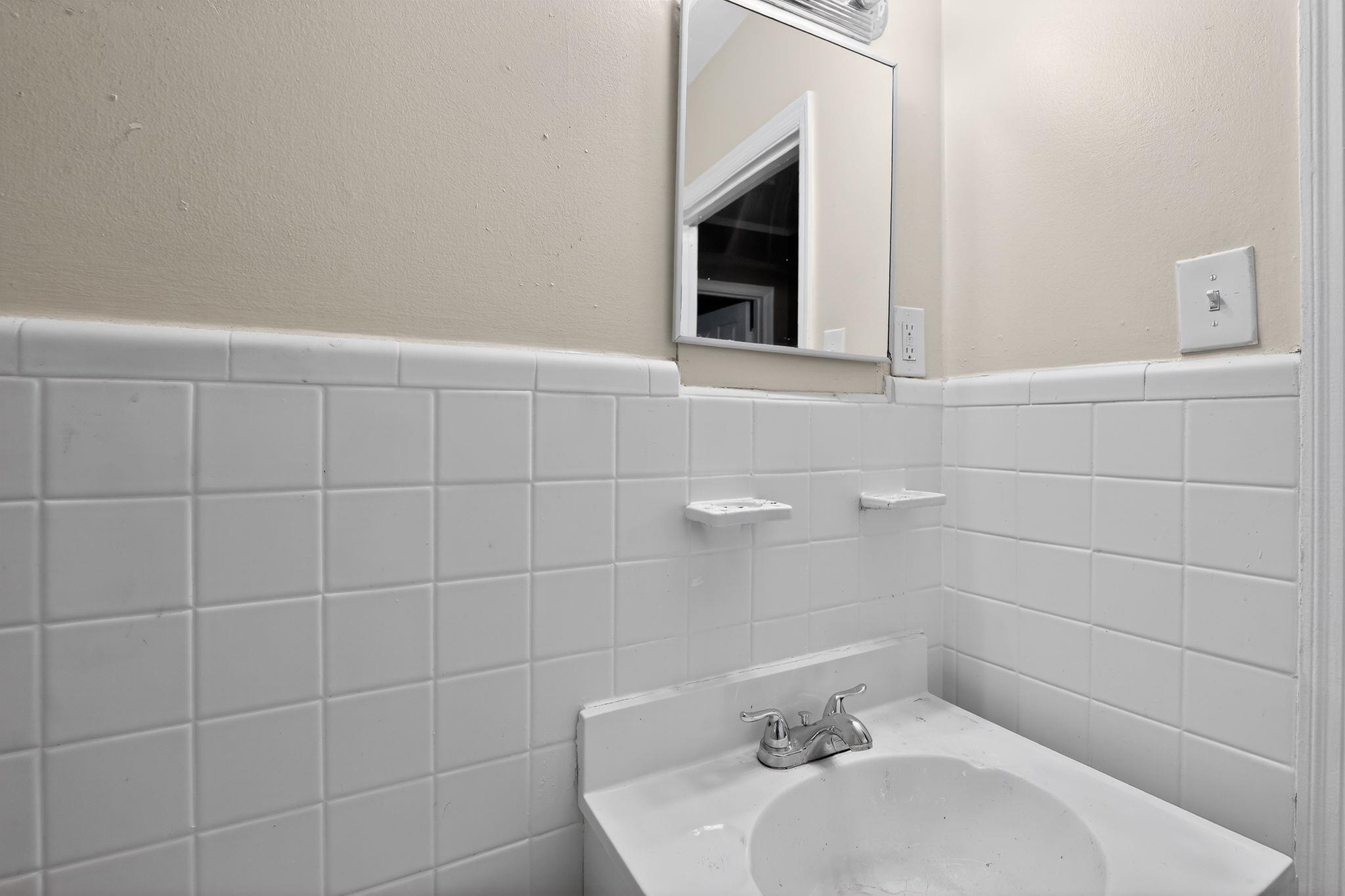 4067 Grantham Road Memphis, TN 38109 - Photo 28 of 34 Bathroom featuring vanity, tile walls, and a wainscoted wall