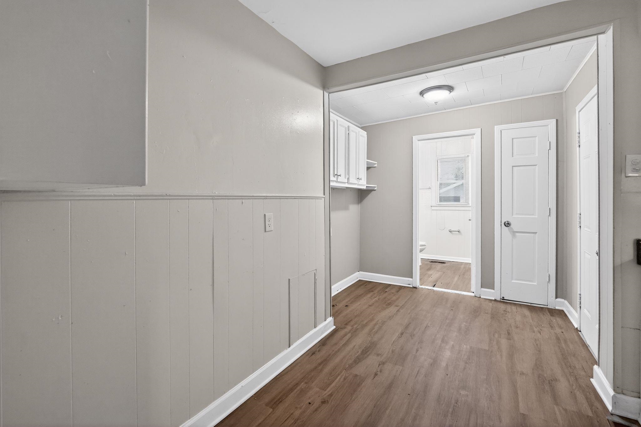 4067 Grantham Road Memphis, TN 38109 - Photo 31 of 34 Laundry area with dark wood finished floors, wood walls, and a wainscoted wall